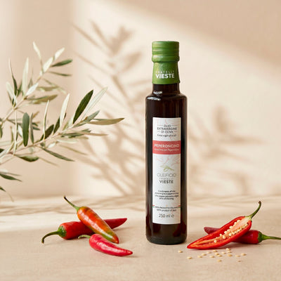 Olio aromatizzato al peperoncino del Gargano versato su un piatto. Oleificio Fratelli Vieste
