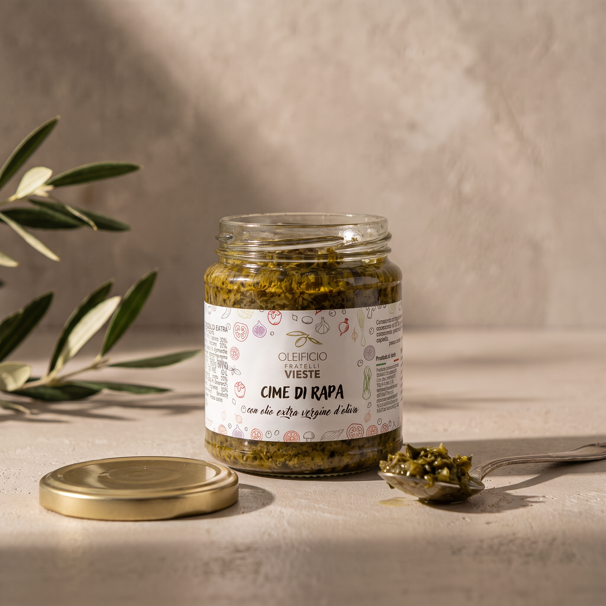 Vasetto aperto di cime di rapa in olio extravergine con un cucchiaino. Oleificio Fratelli Vieste