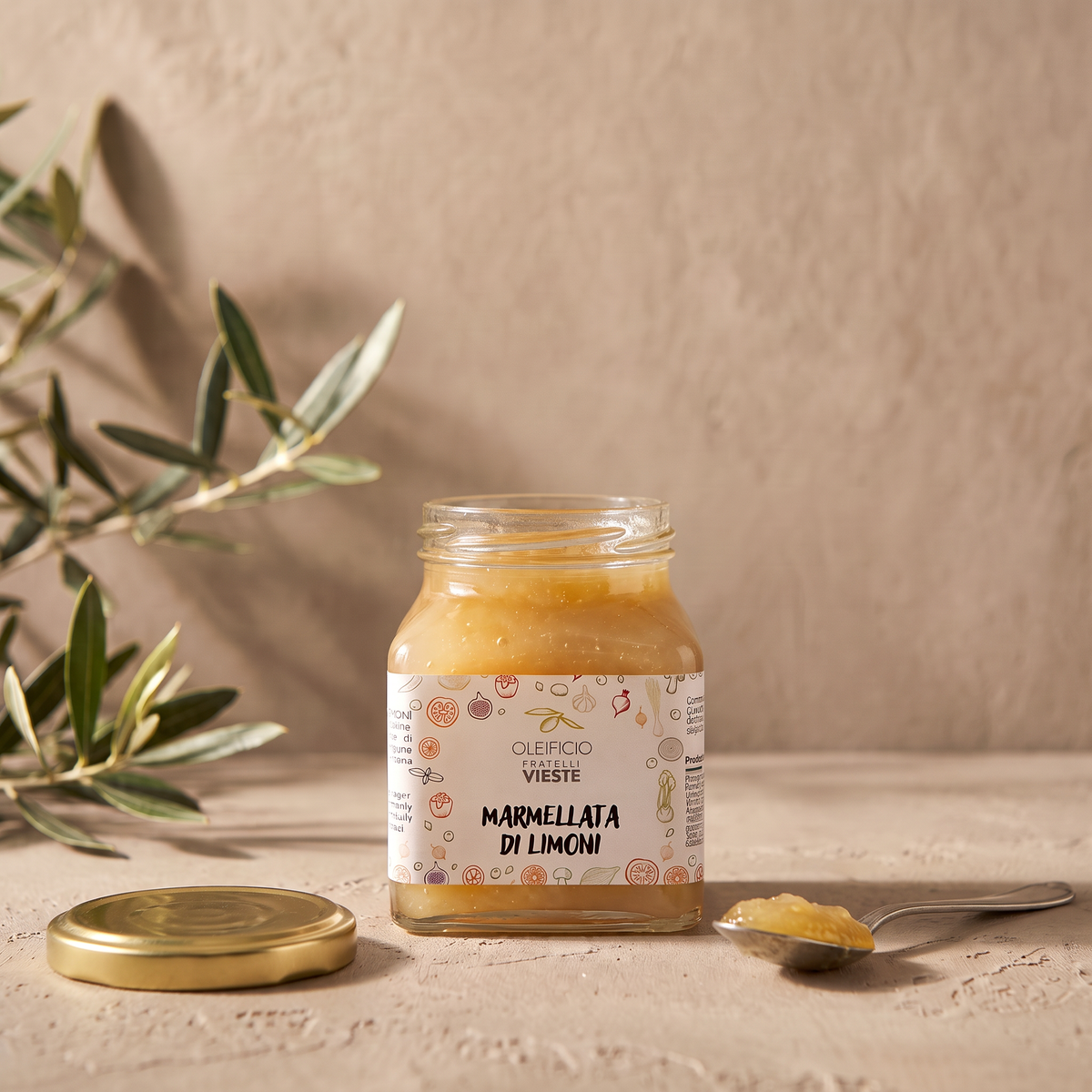 Vasetto aperto di marmellata di limoni con un cucchiaino. Oleificio Fratelli Vieste