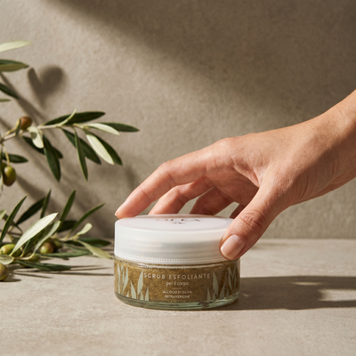 Scrub esfoliante corpo Olea Cosmetic tenuto in mano. Oleificio Fratelli Vieste