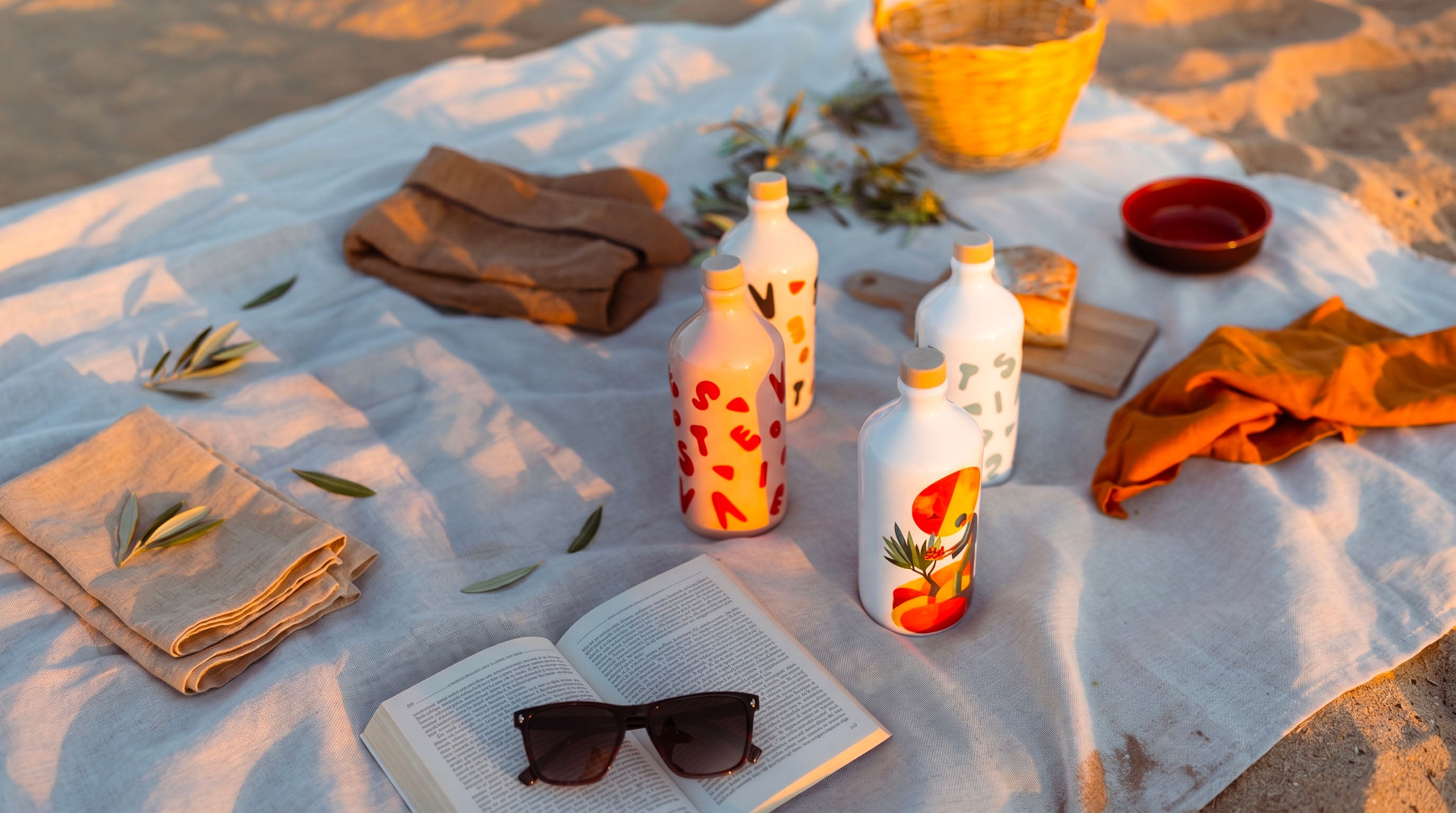 Orci decorati Colorful Vieste su un telo da picnic in spiaggia al tramonto. Oleificio Fratelli Vieste